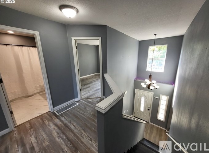 A room with a door, a window, and a chandelier.