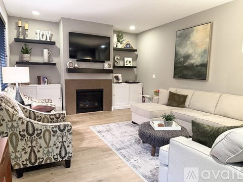 A living room with a fireplace and a television on the wall.