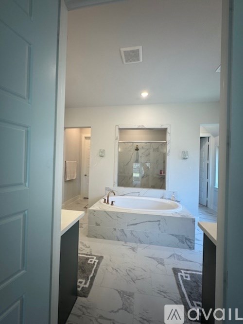 A bathroom with a marble countertop and a large mirror.