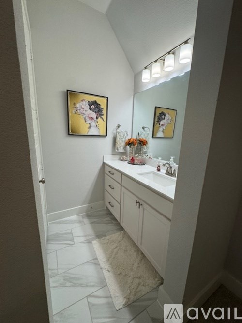 A bathroom with a white sink and a mirror.