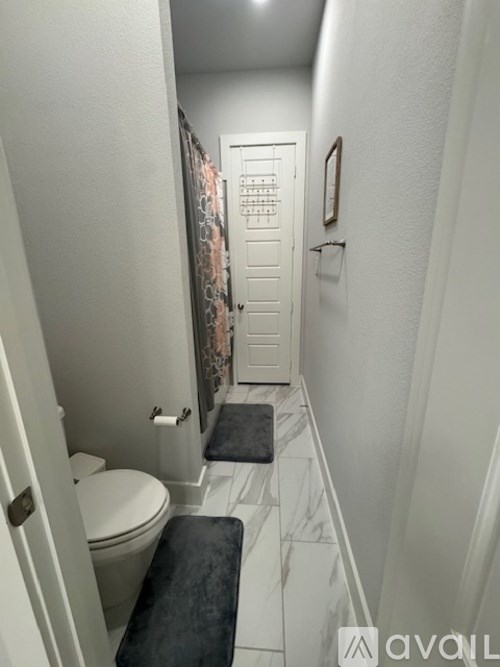 A bathroom with a toilet, a bench and a door.