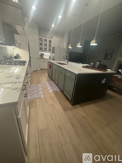 A kitchen with wooden floors and a marble countertop.