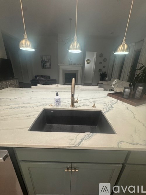 A kitchen with a marble countertop and a sink.