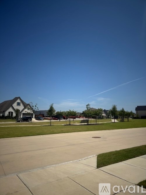 A clear blue sky over a residential area with houses and trees.