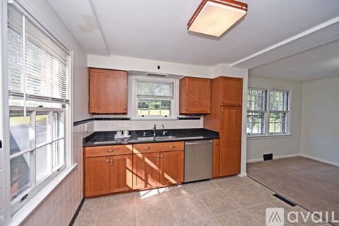 A kitchen with wooden cabinets and a black countertop is available.