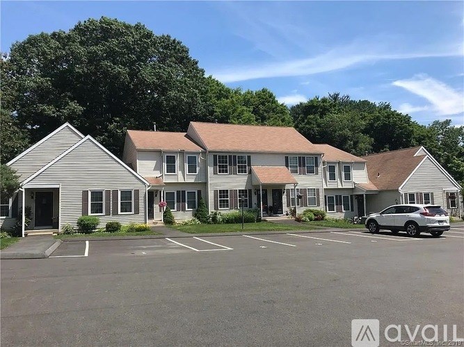 A parking lot in front of a building with a car parked.