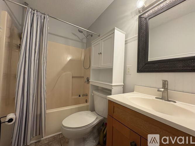 A bathroom with a toilet, sink, and shower.