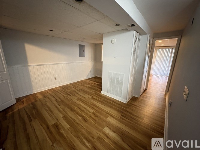 A room with wooden flooring and white walls.