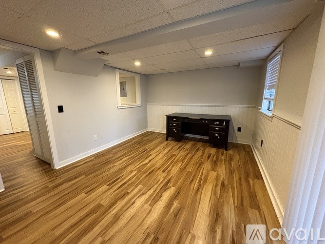 A room with wooden flooring and a black cabinet.