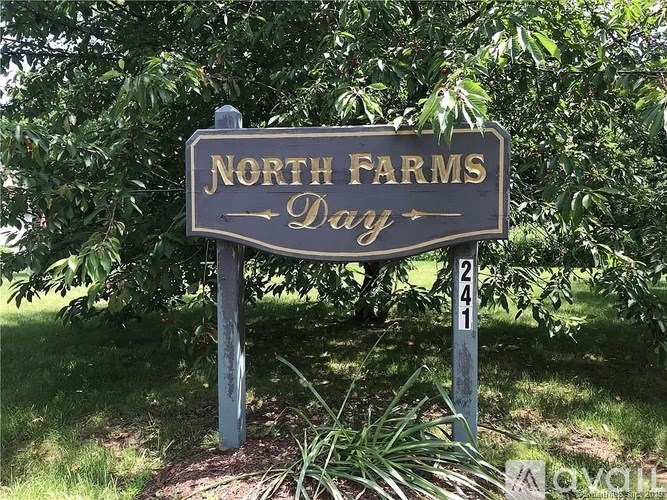 A sign that says North Farms Day is in front of some trees.