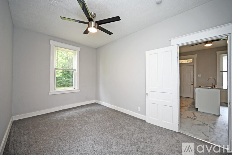 A room with a ceiling fan and a window.
