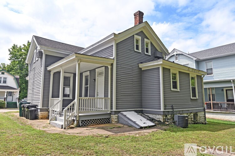 A house with a grey exterior and a white porch.