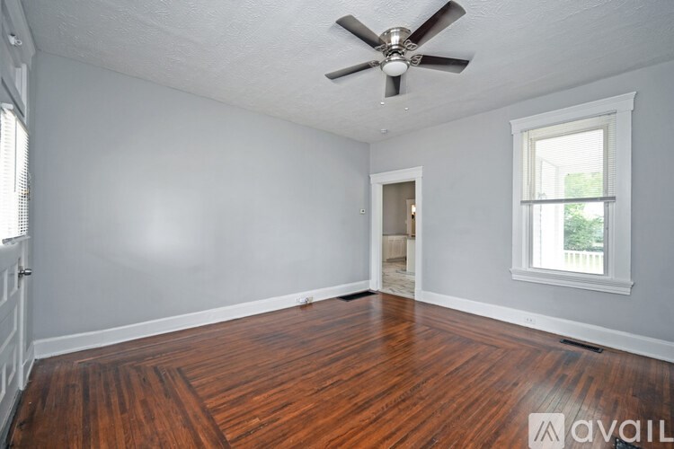 A room with a ceiling fan and wooden flooring.