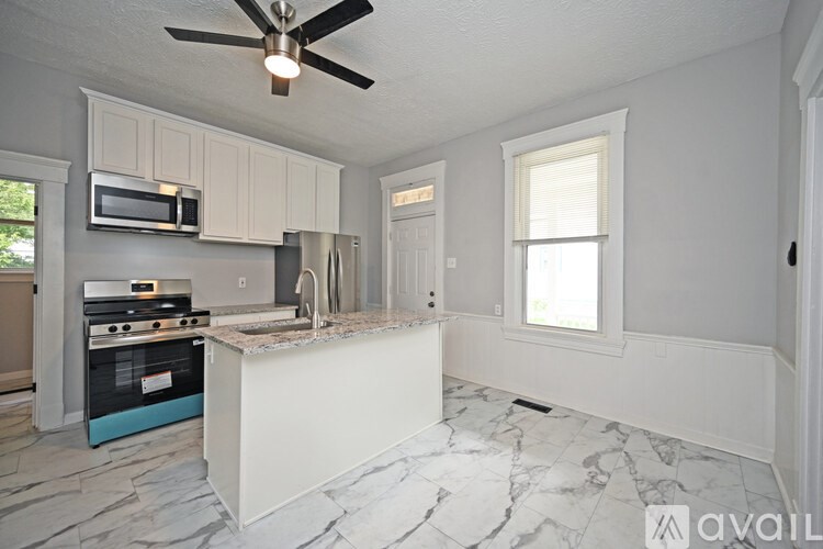 A kitchen with a marble countertop and a ceiling fan.