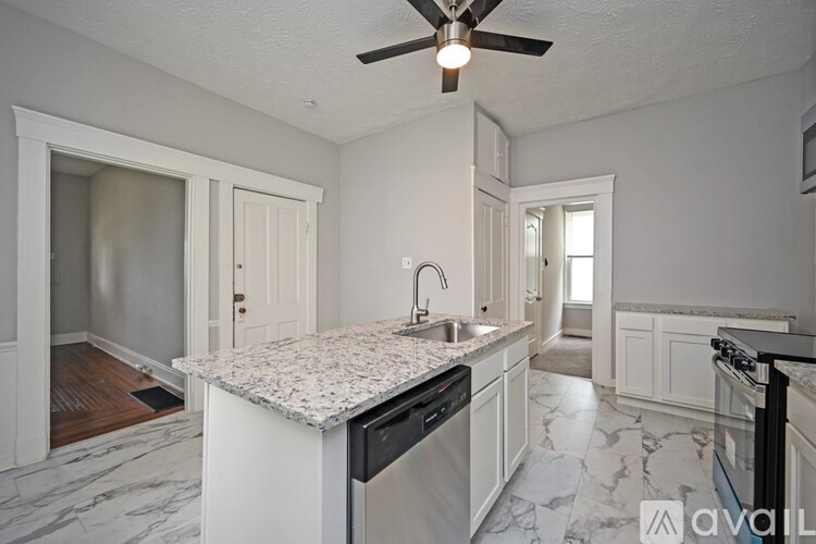 A kitchen with a marble countertop and a ceiling fan.
