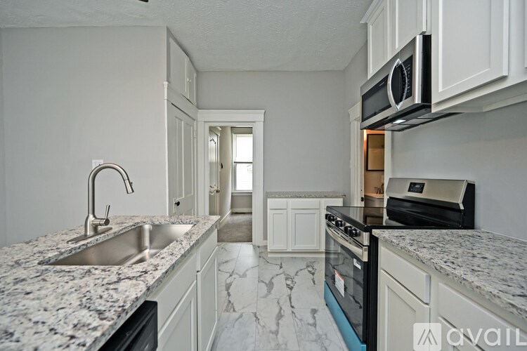 A kitchen with granite countertops and white cabinets.