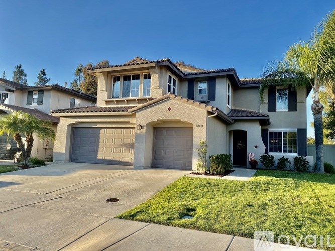 A two-story house with a garage and a driveway.