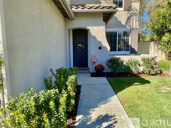 A house with a blue door and a small garden in front.