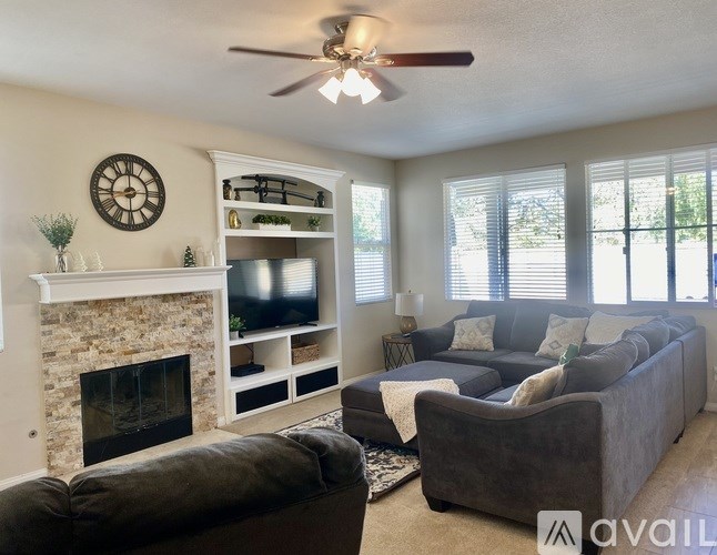 A living room with a fireplace, couch, and television.
