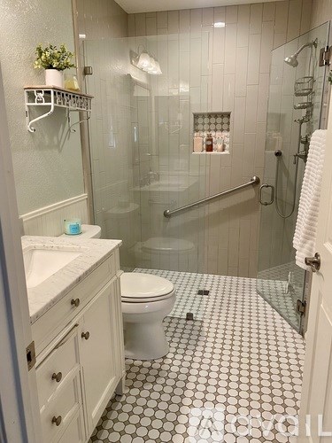A white toilet in a bathroom with a tiled floor.