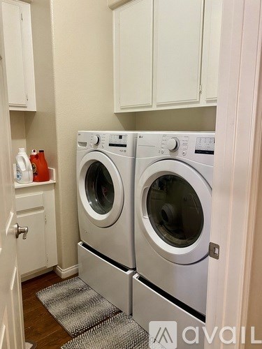 Two front loading washing machines in a small laundry room.