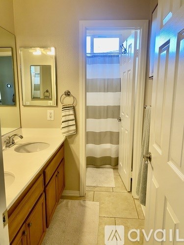 A bathroom with a sink, mirror, and towel rack.