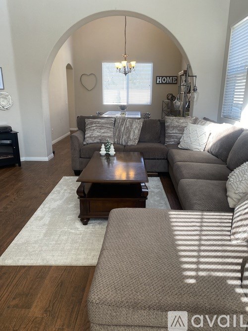 A living room with a couch, coffee table, and a rug.