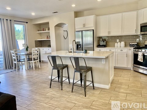 A kitchen with white cabinets and a tile floor.