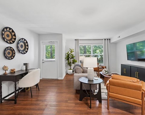 A living room with a brown leather couch and a black dining table.