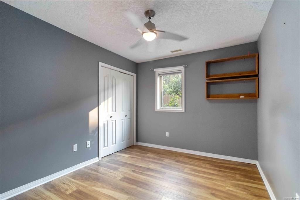 A room with a wooden floor and a ceiling fan.