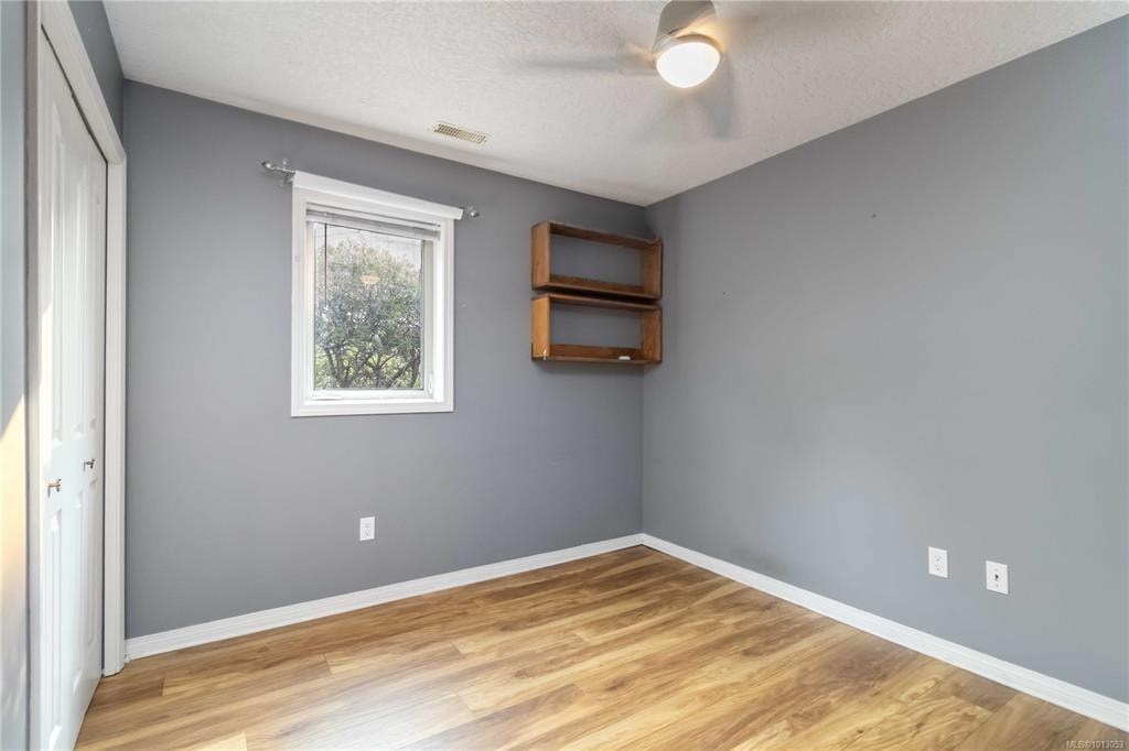 A room with a window and a wooden shelf.