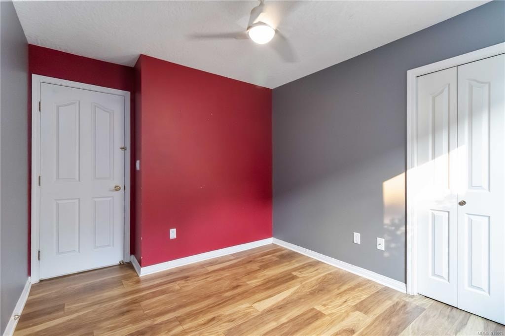 A room with a red wall and a white door.