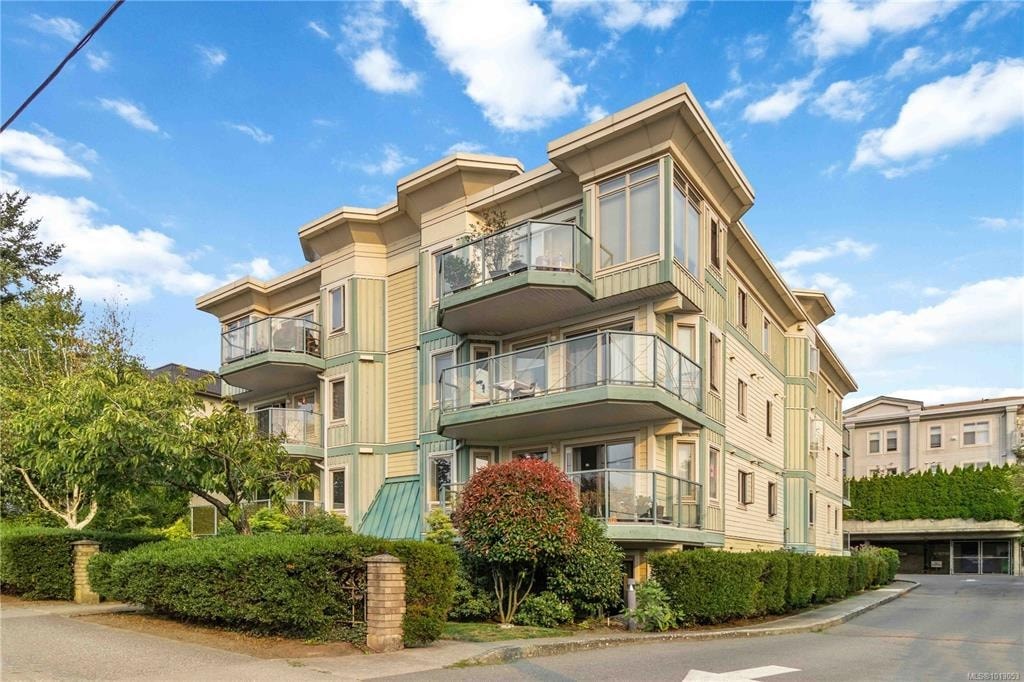 A large, two-story residential building with a balcony on the second floor.
