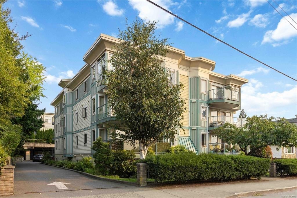 A large two-story building with a green and white exterior.