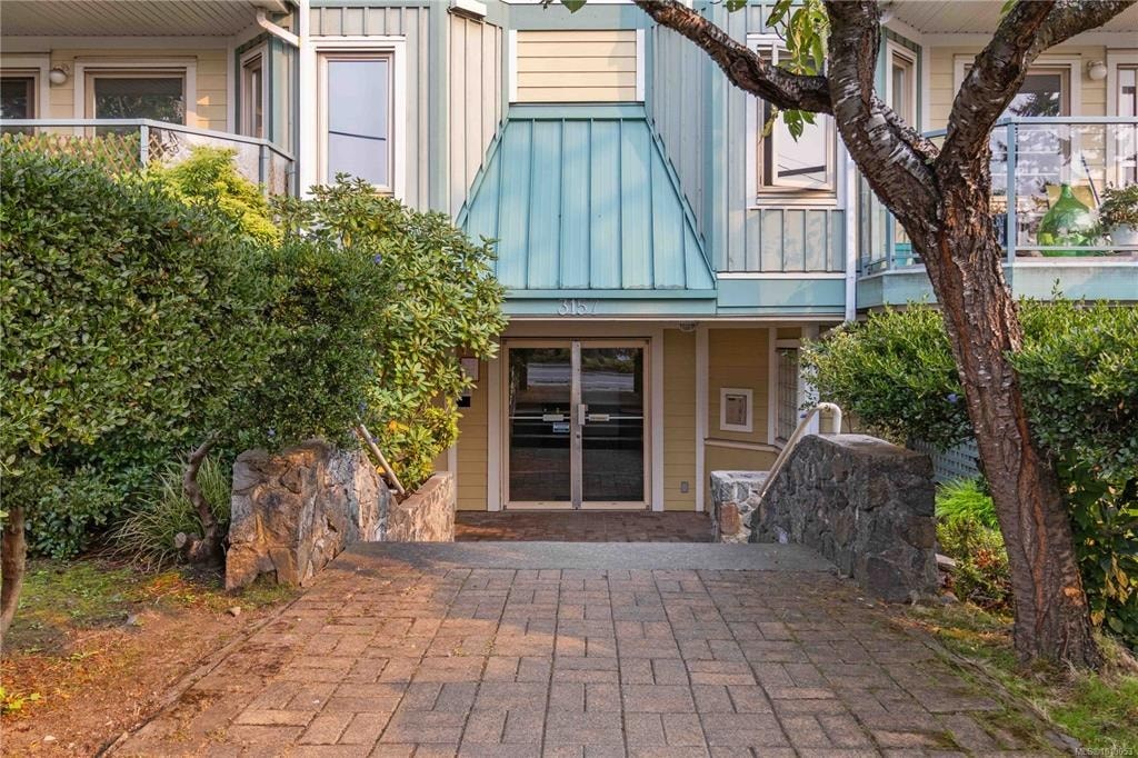 A house with a green roof and a stone wall.