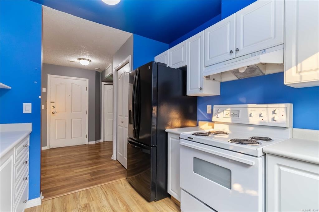 A kitchen with blue walls and white appliances.