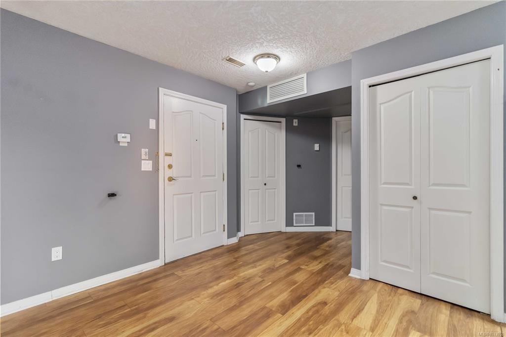 A room with a white door and a grey wall.