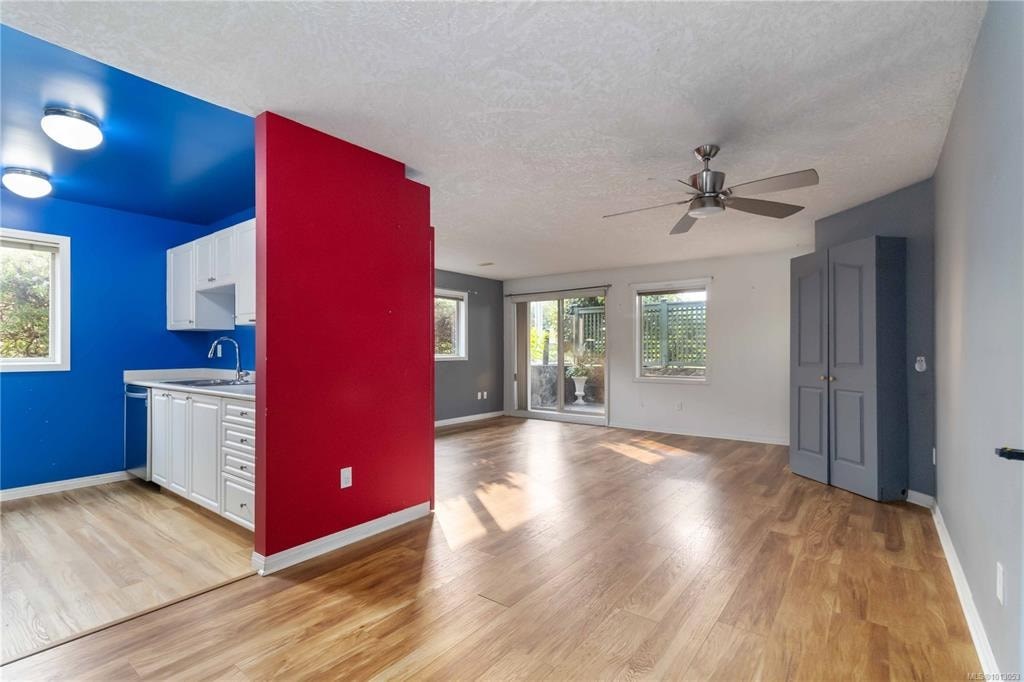 A room with a red and blue wall and a ceiling fan.