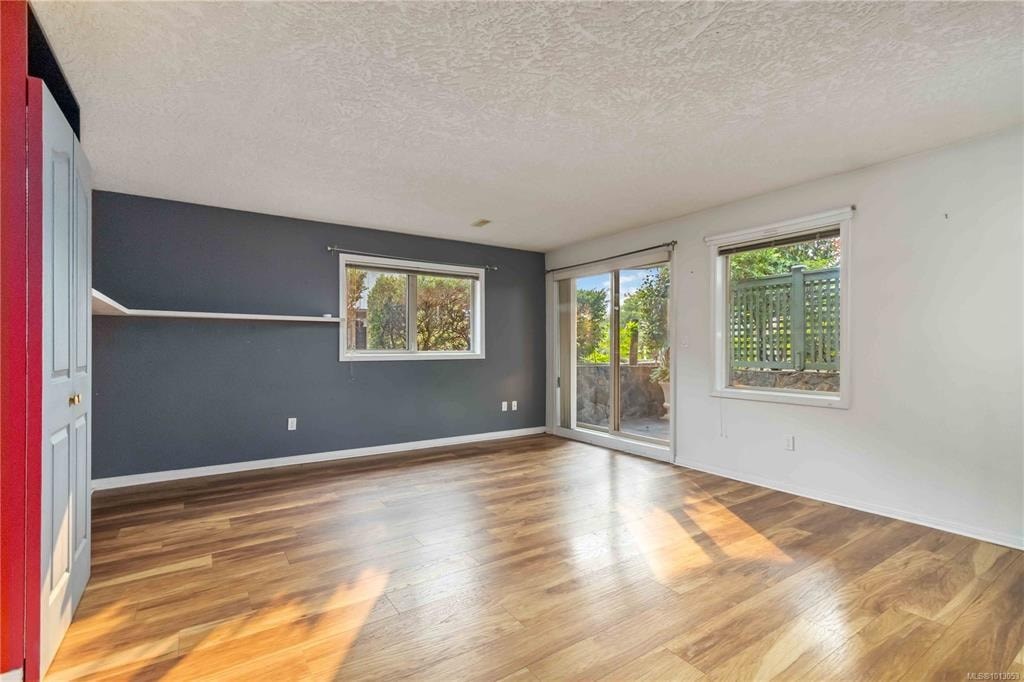 A room with wooden floors and two windows.
