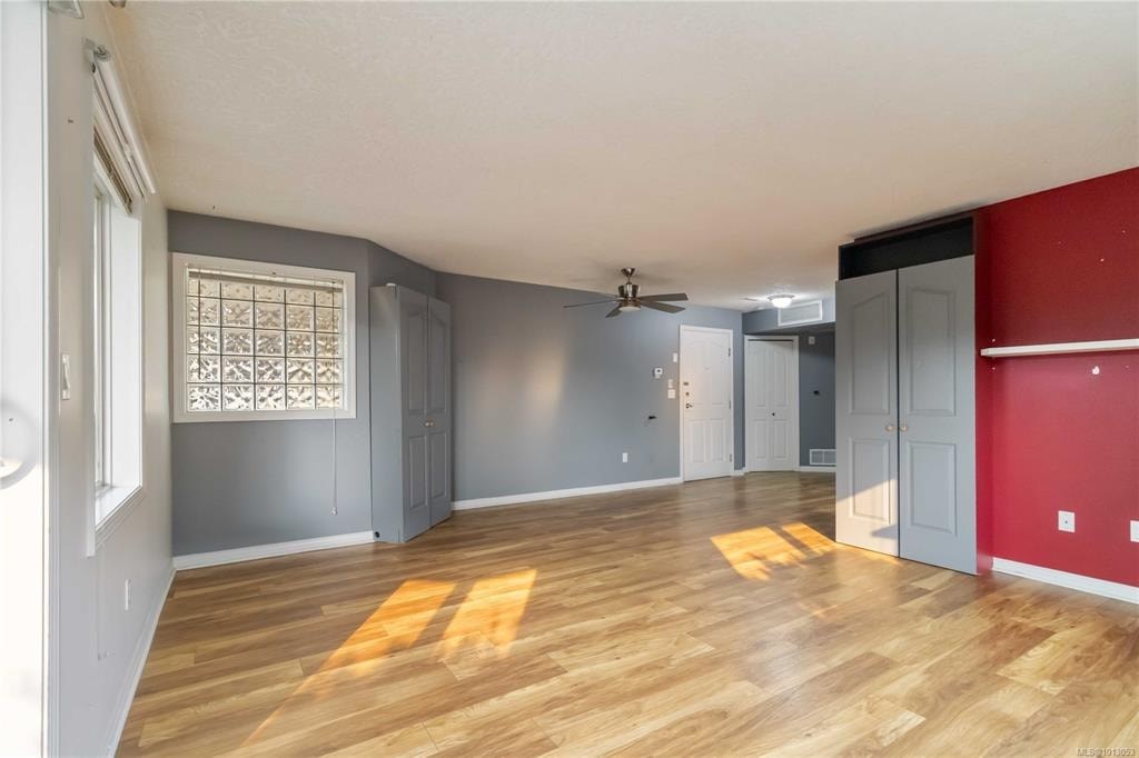 A room with wooden floors and a ceiling fan.