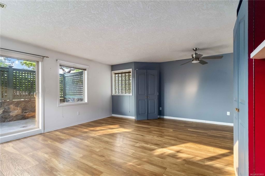 A room with wooden flooring and a ceiling fan.