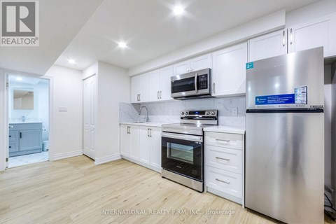 A modern kitchen with white cabinets and stainless steel appliances.