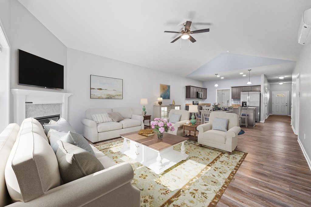A living room with a beige couch, a coffee table, and a rug.