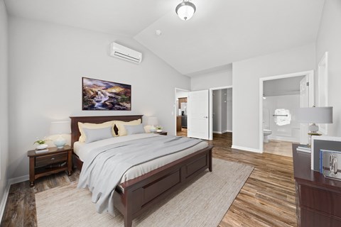 A bedroom with a large bed and a painting on the wall.