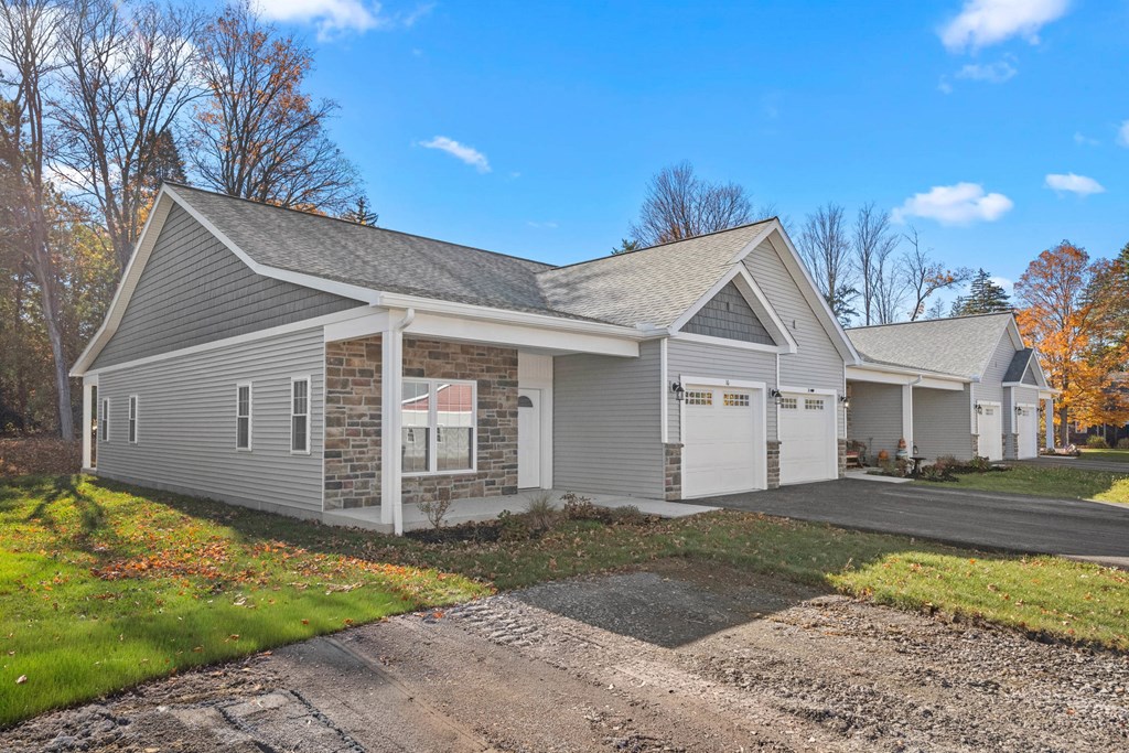 A house with a grey roof and white garage doors.