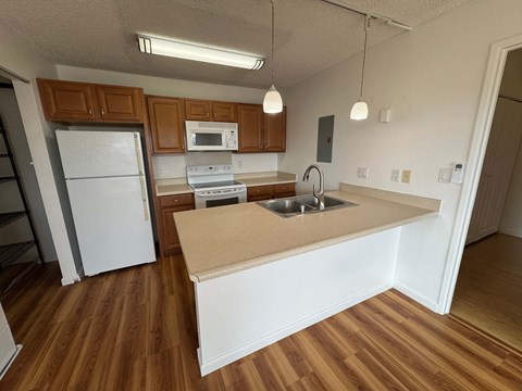 A kitchen with wooden cabinets and a white fridge.