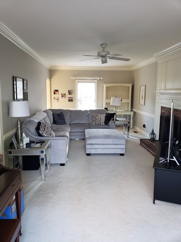 A living room with a grey couch and a white chair.