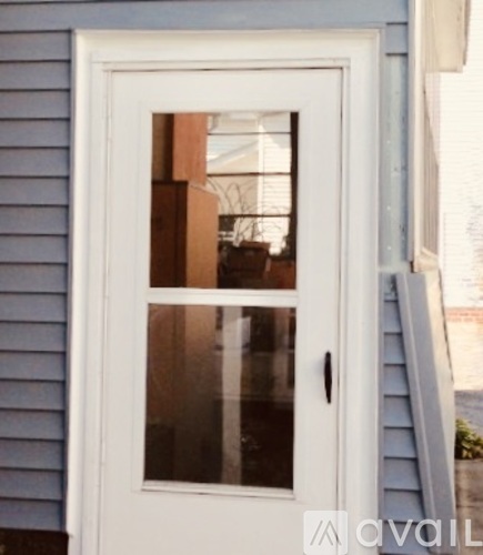 A white door with a glass window is set in a blue wall.