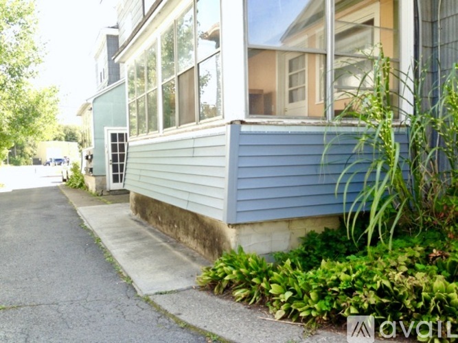 A house with a blue siding and a white door is shown.