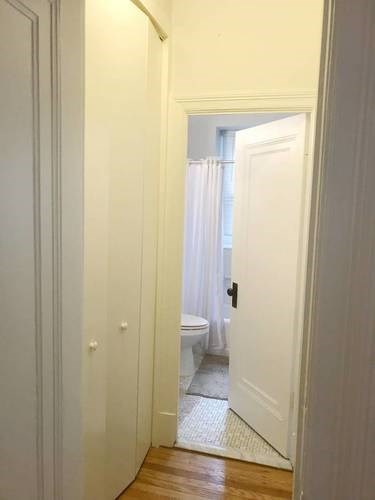 A white door is open to a bathroom.